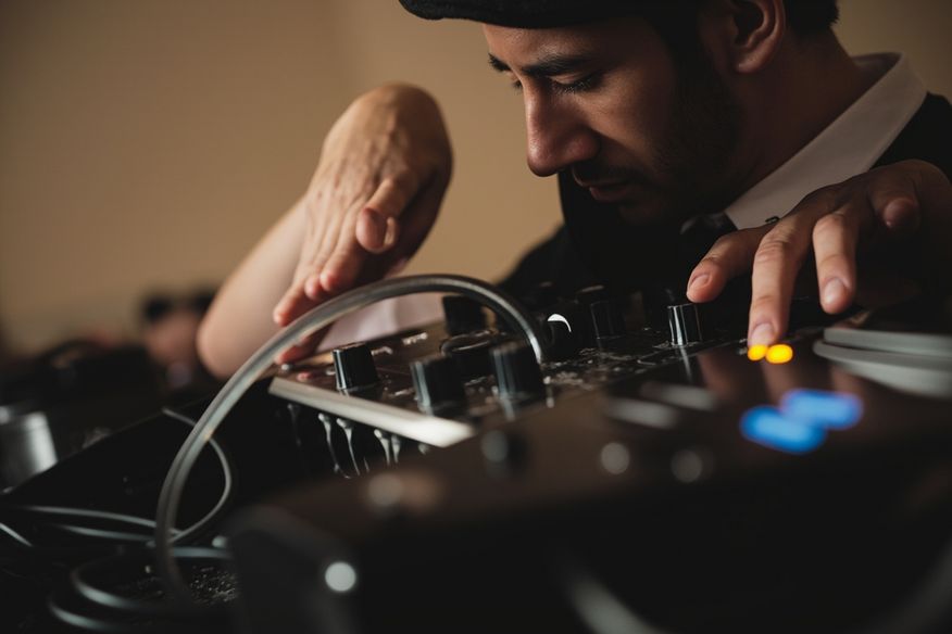 DJ ajustando mesa de som em cabine de evento corporativo