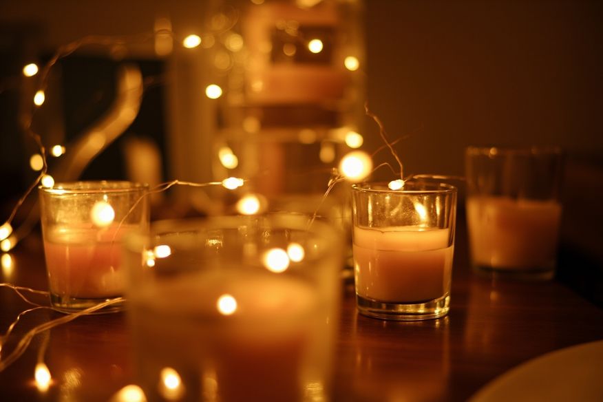 Iluminação ambiente com pisca-pisa e velas em festa adulta à noite