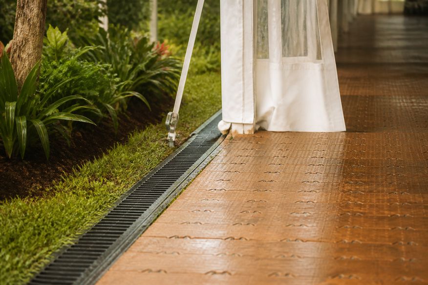Piso modular seco e drenagem preparada na entrada de uma tenda de festa