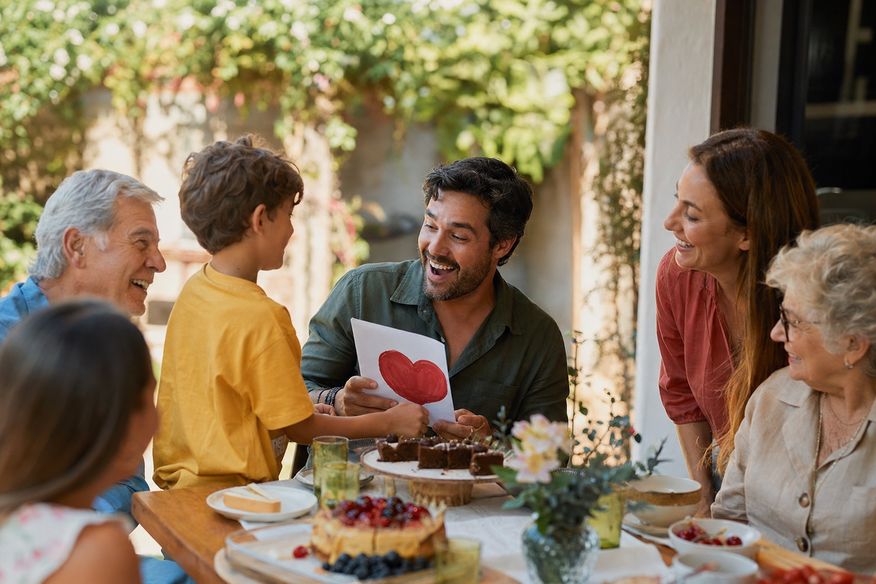 Família compartilha sobremesa e presente feito por criança após o almoço.