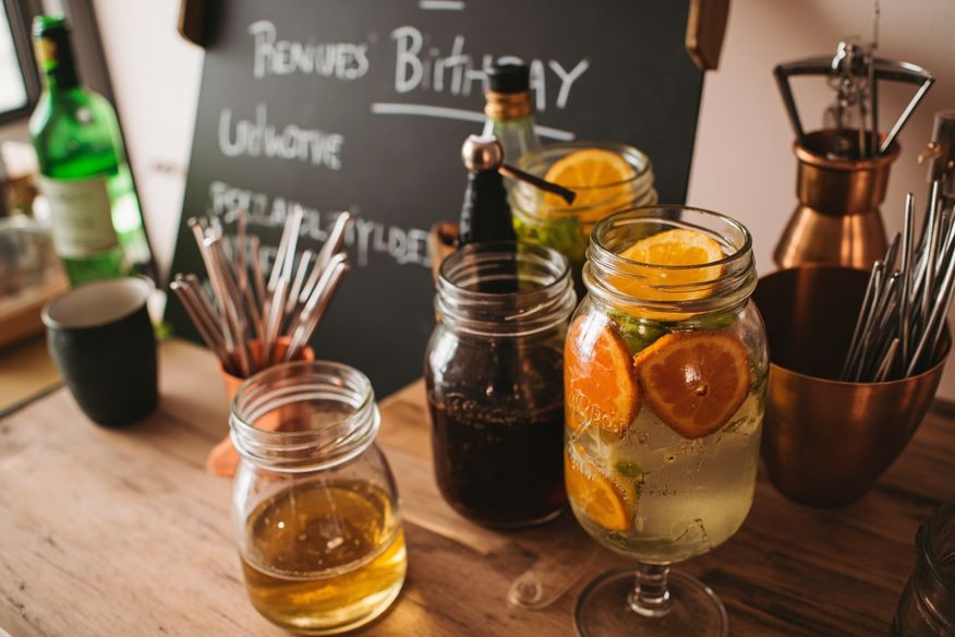 Bar de drinks artesanais com frutas cítricas, ferramentas de cobre e cardápio em quadro negro